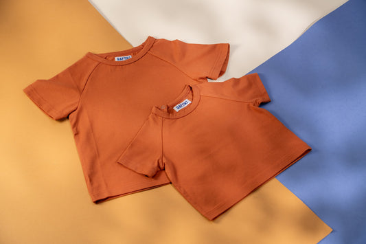 Brown t-shirt with a brand label on a multicolored background